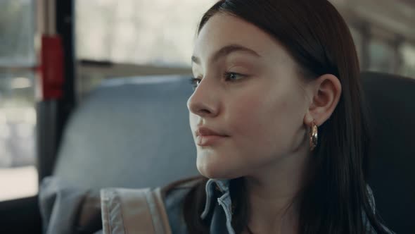 Closeup Brunette Girl Looking in Camera Sitting in Empty School Bus Alone