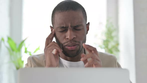 Close Up of African Man Having Headache While Using Laptop