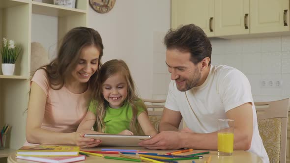 Happy Family Viewing Photos on Tablet, Girl Sliding Pictures on Touchscreen