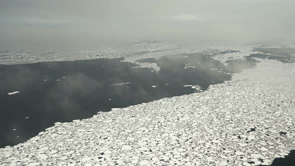 Chunks of Ice on the Water. Aerial View. Lots of Broken Ice. Low Cloud. The Ice Is Melting