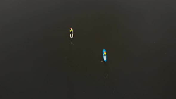 Drone Shot of Man and Woman on Sup Paddle Boards at Wide River Bird Eye View