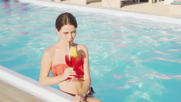 Gorgeous Woman Enjoying Cocktail at the Swimming Pool