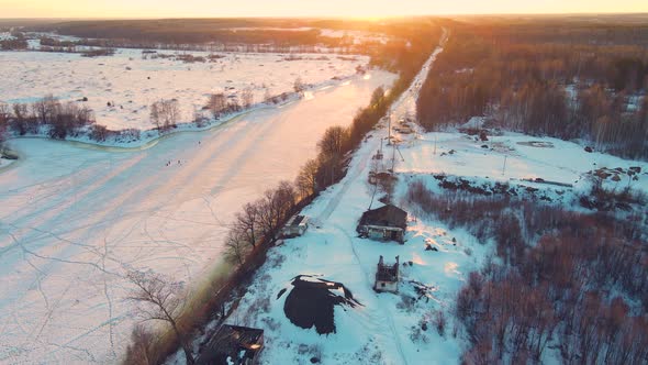 A Majestic Winter Landscape with a Frozen River at Sunset Aerial View