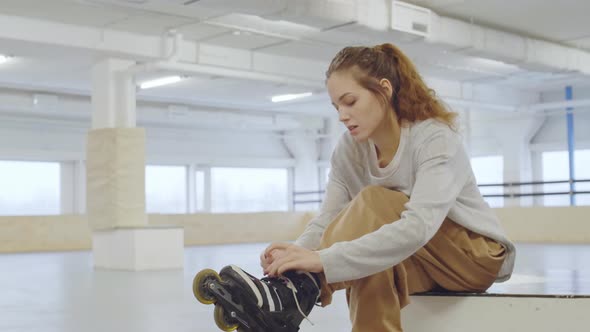 Beautiful Woman Putting on Black Roller-Skates