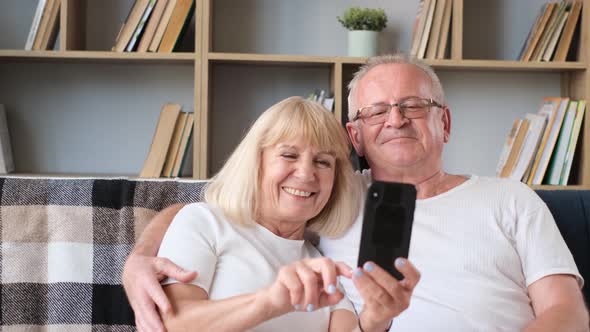 A Happy Elderly Married Couple Chatting Online with Their Relatives and Children