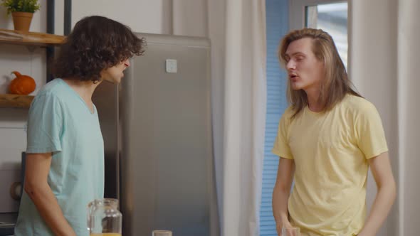 Worried Gay Couple Arguing During Lunch in Kitchen at Home