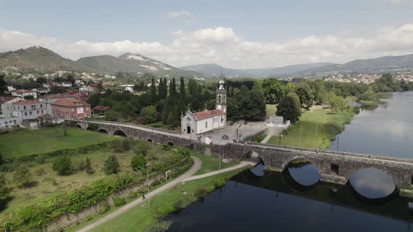 Orbiting over Old church near Roman Brigde, Lima riverside, Beautiful Portuguese Countryside