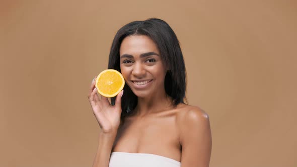 Delighted African American Female with Showing Halves of Fresh Juicy Orange Health and Beauty on