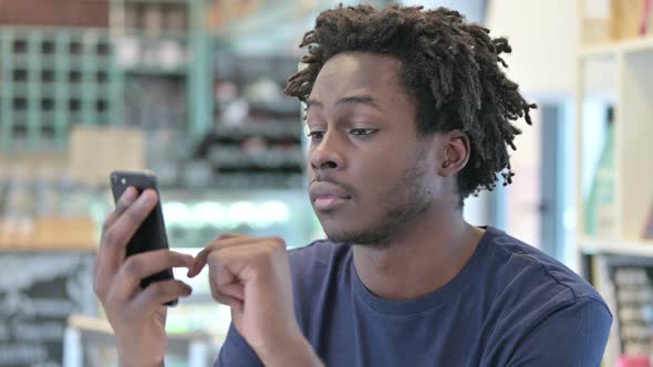 Portrait of African Man Celebrating on Smartphone