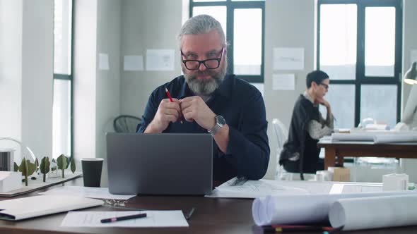 Portrait of Senior Architect at Office Desk