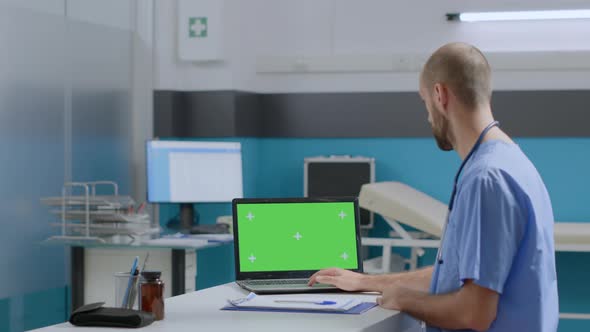 Therapist Man Nurse Sitting at Desk Typing Sickness Expertise on Mock Up Green Screen Chroma Key