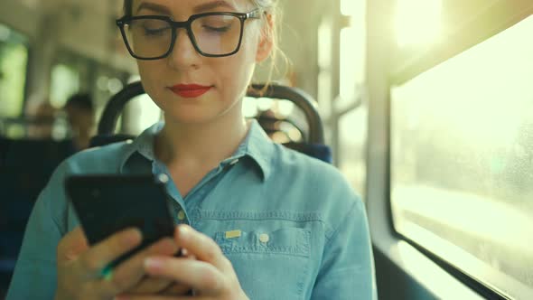 Woman in Tram Using Smartphone Chatting and Texting with Friends