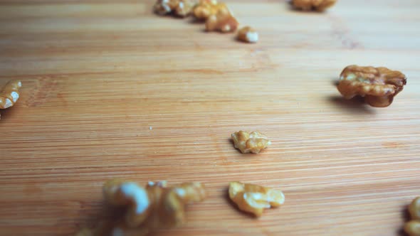 Walnuts falling on a wooden cutting board