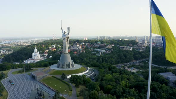 Aerial View of the Ukrainian Flag Waving in the Wind Against the City of Kyiv