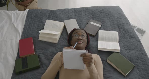 Black Race Girl Studying While Lying in Bed