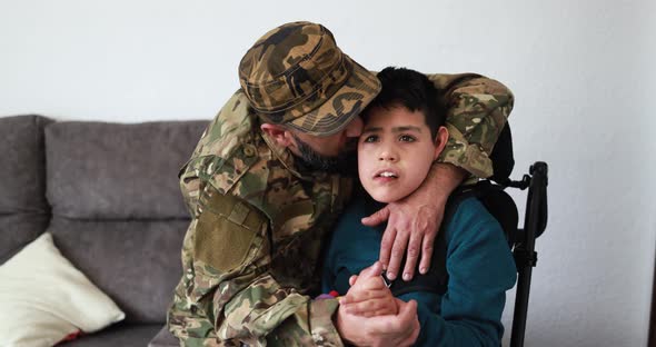 Happy veteran soldier man hugging his son in wheelchair after returning from military