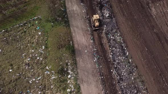 Bulldozer Collects Garbage in a Pile