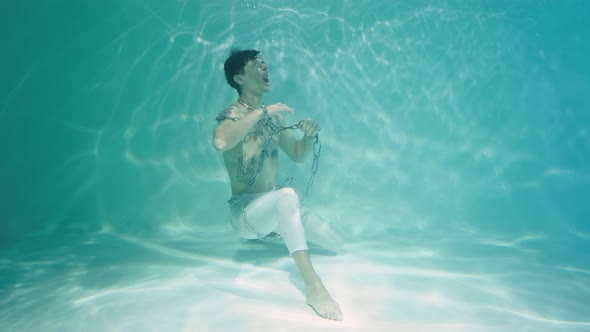 Underwater Shot of Young Man Entangled in Chains