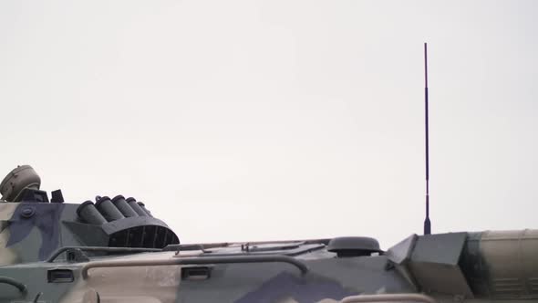 Military Equipment of Armored Personnel Carriers Against the Background of a White Cloudy Sky