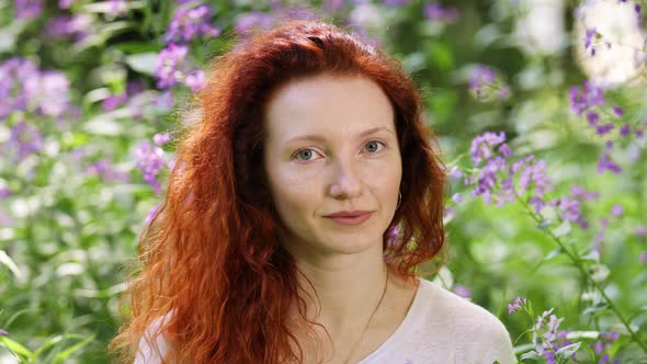 Portrait of a Redhead Woman Among Flowers