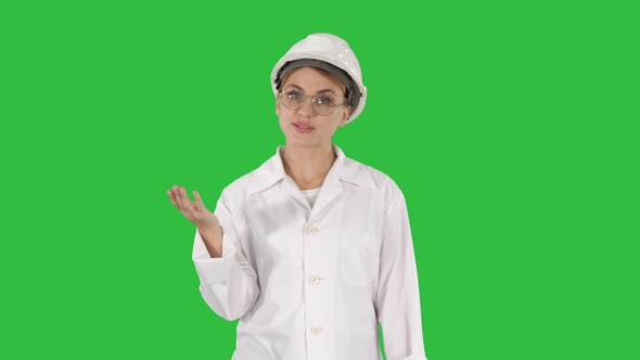 Mature engineer woman in hard hat and lab coat talking