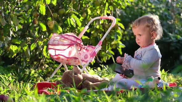 Happy Little Girl Sitting on the Green Grass