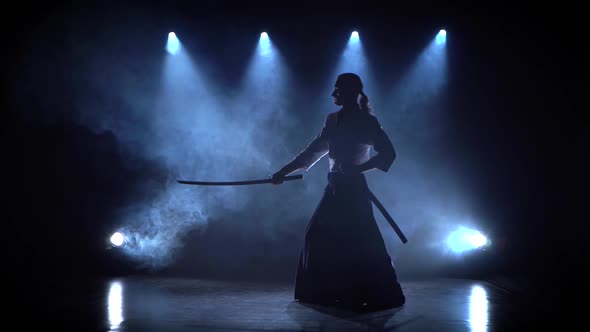 Aikido Master Technique Demonstration with Japanese Sword Katana. Silhouette on Black Studio