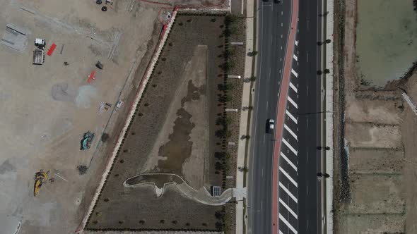 Aerial view of a large construction site next to a newly built main road