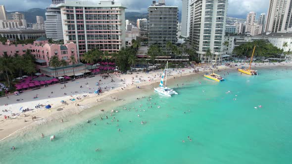 A drone rotates showing an aerial view of a tropical island beach.