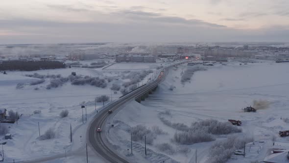Aerial View of the Bridge Over the Frozen River in the Arctic City