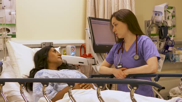 Nurse delivers bad news to a female patient in a hospital bed.