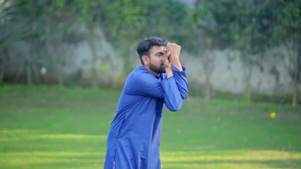 Indian man doing Garudasana or Eagle Yoga Pose in a park