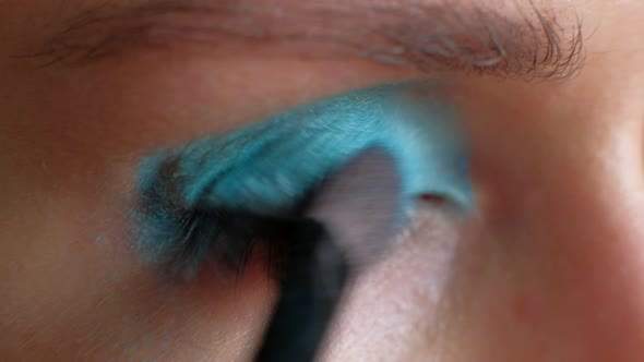 Macro Footage  Woman Puts Bright Blue Makeup on Her Eyes