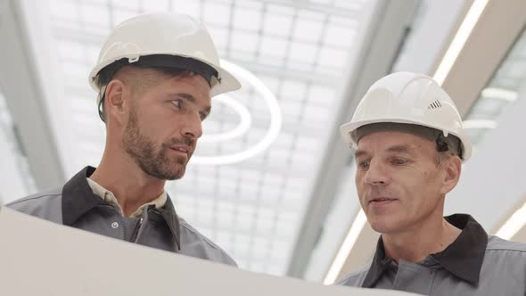 Men in Safety Helmets Talking