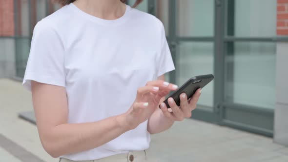 Woman Browsing Internet on Smartphone while Walking on Street