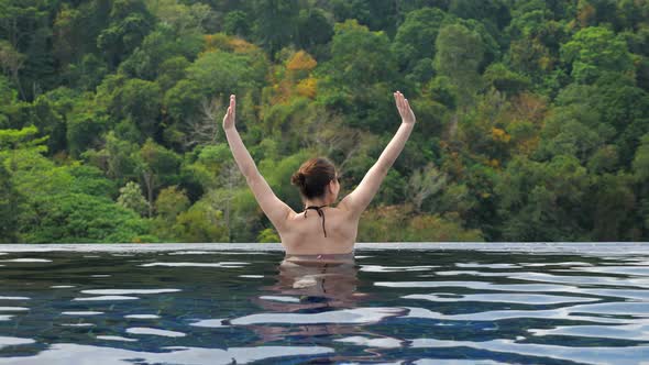 Brunette in Bikini Stretches in Hotel Outdoor Swimming Pool