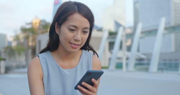 Woman use of mobile phone for online in city