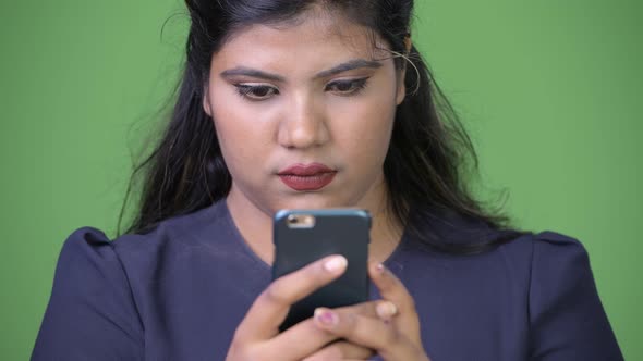 Young Overweight Beautiful Indian Businesswoman Against Green Background