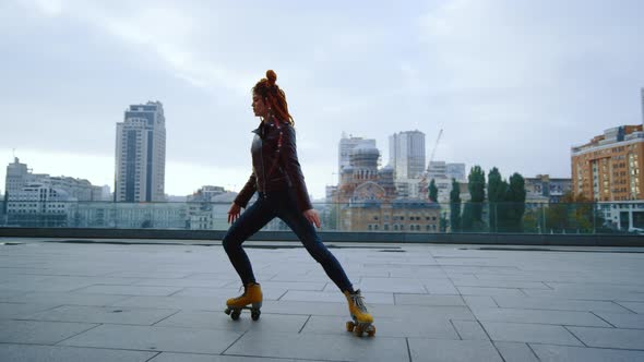 Sporty Ginger Woman Performing Elements of Rollerblading on Urban Background