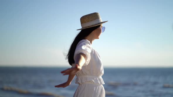 Woman Traveller with Arms Raised Looking at Sea