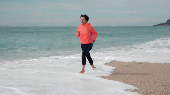 Young woman runs on tropical beach. Healthy and fitness lifestyle. 