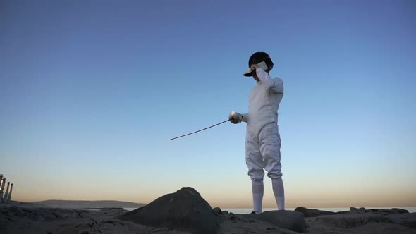 A man and woman fencing on the beach