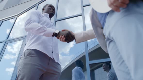 Low Angle of Handshake of African and Caucasian Businessmen