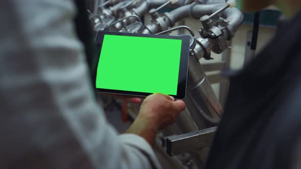 Engineer Hands Swiping Tablet with Chroma Key Screen at Steal Equipment Closeup