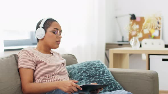 Woman with Tablet Pc Listening To Music at Home