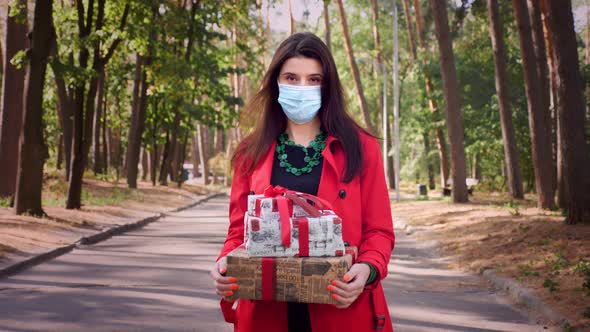 Wrapped Gifts. a Woman in a Protective Mask Holding Several Beautifully Packed Boxes in Her Hands