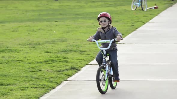 A boy riding a bike in a park.