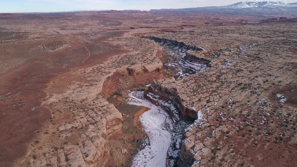 Aerial view flying over canyon cutting through the landscape in Utah