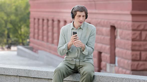 Overjoyed Millennial Man Wearing Modern Headphones Have Fun Moving Listening Music Favorite Tracks