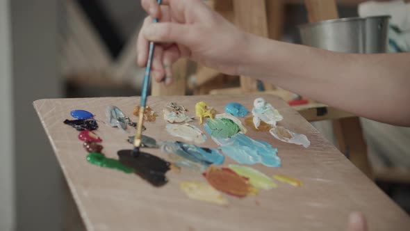 Artist Is Mixing Colours on Palette and Applying on Canvas